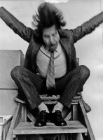 Brock auf Holztreppe sitzend, gestikulierend